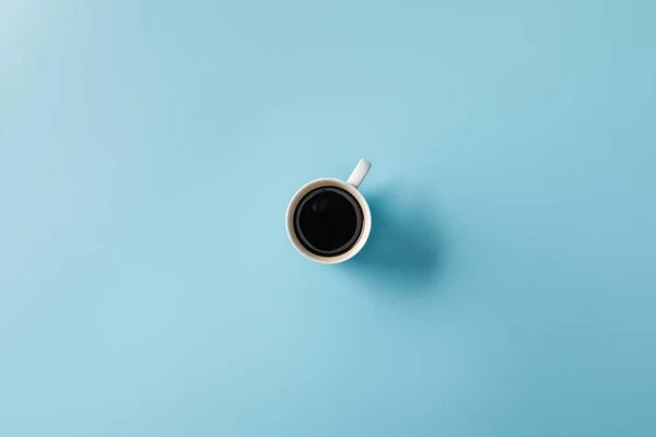 Vue du dessus du café en tasse sur fond bleu — Photo de stock