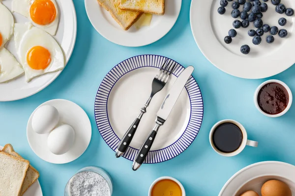 Top view of table setting for breakfast on blue background — Stock Photo