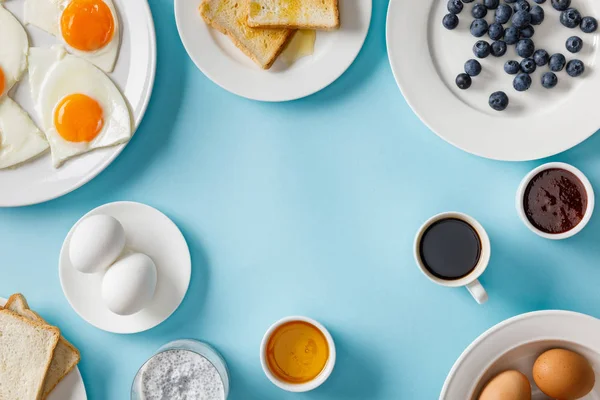 Верхний вид сервировки стола для завтрака на синем фоне — стоковое фото