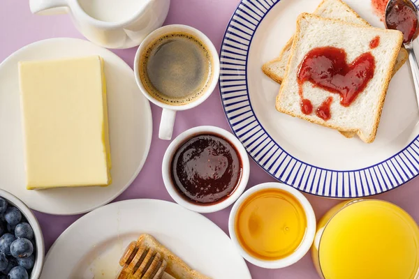 Vista superior de la mesa de configuración de desayuno enemigo sobre fondo violeta - foto de stock