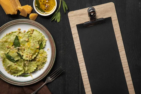 Top view of served ravioli and empty black menu template — Stock Photo