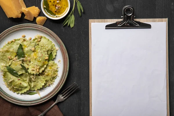 Top view of served ravioli and empty white menu template — Stock Photo