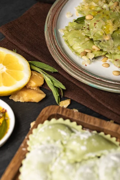 Селективный фокус зеленых вкусных равиоли с кедровыми орехами на тарелке — стоковое фото