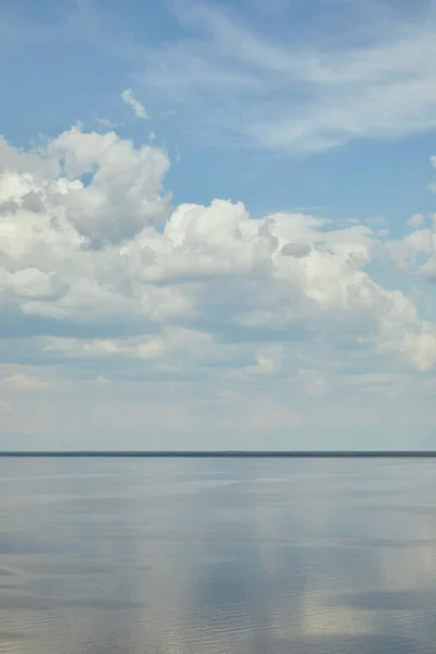 Paysage paisible avec rivière et nuages blancs sur ciel bleu — Photo de stock