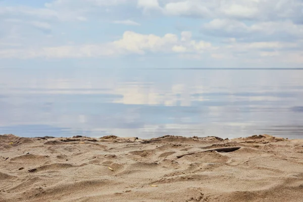 Spiaggia di sabbia vicino al fiume con cielo blu riflesso in acqua — Foto stock