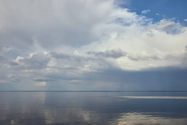 Pacifico cielo blu con nuvole bianche riflesse nell'acqua del fiume — Foto stock