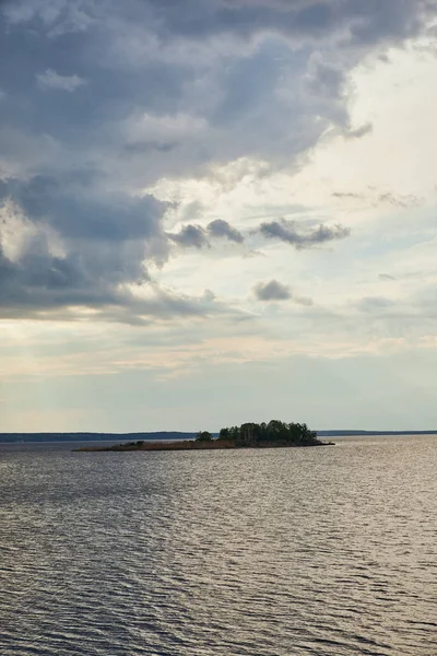 Голубые облака на светлом голубом небе над рекой с лесом на острове — стоковое фото