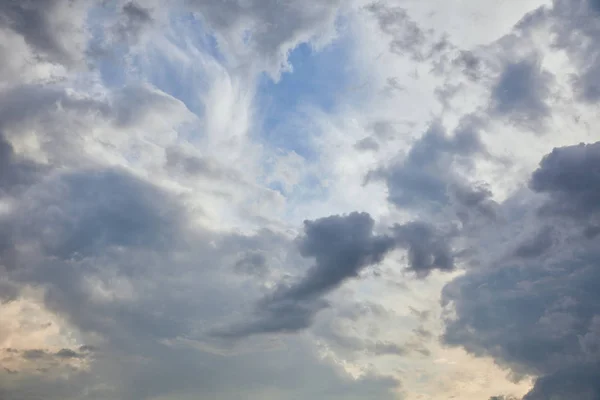 Blue clouds on blue sky background and sun rays — Stock Photo