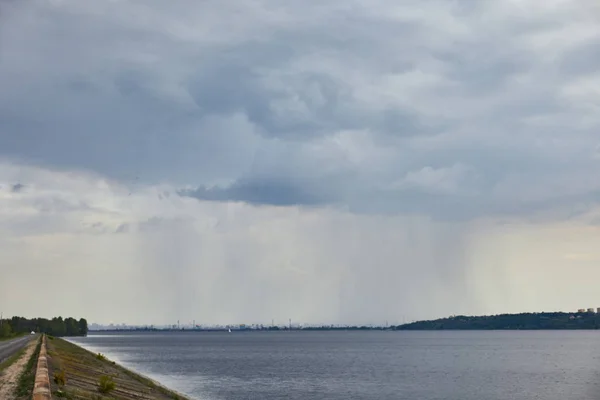 Overcast view of blue clouds, rain and coast — Stock Photo