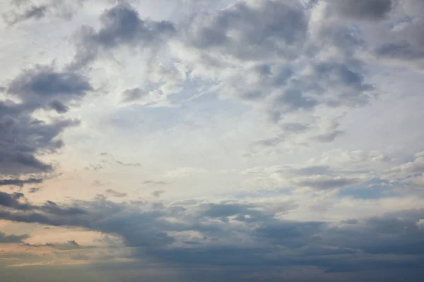 Nubes azules sobre fondo de cielo gris y rayos de sol - foto de stock