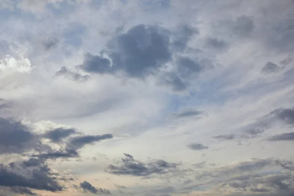 Blue clouds on blue sky background and sun rays — Stock Photo