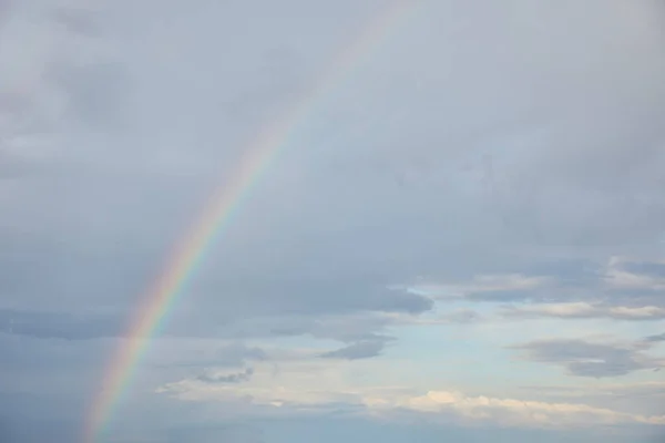 Regenbogen auf blauem Himmel Hintergrund mit weißen Wolken — Stockfoto