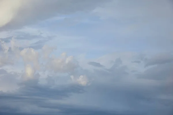 Vista de nubes grises sobre fondo azul del cielo - foto de stock