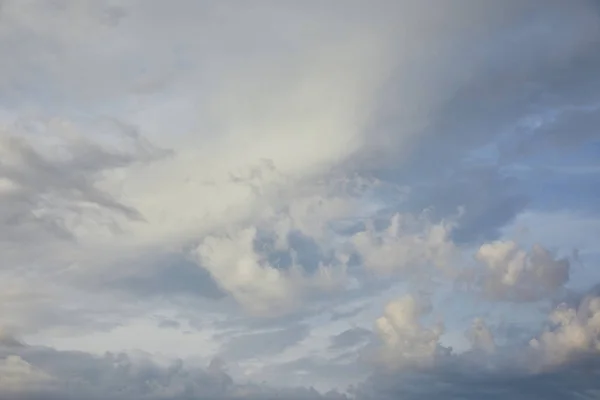 Vista de nubes blancas y grises sobre fondo azul del cielo de la luz solar - foto de stock