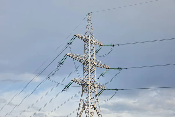 Вид на електричний полюс з довгими дротами на сірому фоні неба — стокове фото