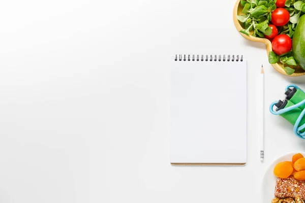 Top view of blank notebook near diet food and skipping rope on white background — Stock Photo