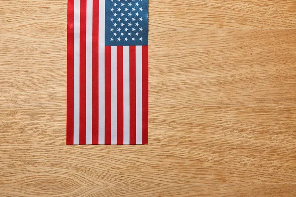 Vue du haut du drapeau américain sur fond beige en bois — Photo de stock