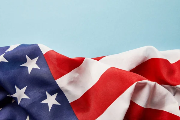 Vista de cerca de la bandera nacional arrugada americana sobre fondo azul con espacio para copiar - foto de stock