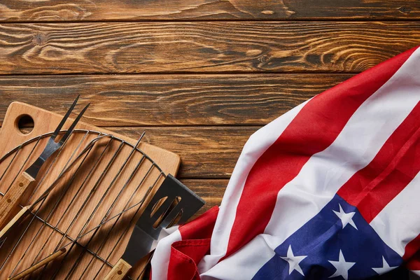 Vue du haut du drapeau américain près des équipements bbq sur table rustique en bois — Photo de stock