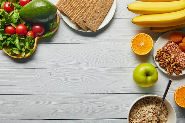 Top view of fresh fruits, vegetables and cereal on wooden white background with copy space — Stock Photo