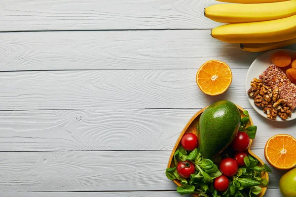 Vue de dessus des fruits frais, légumes dans un bol en forme de coeur sur fond blanc en bois avec espace de copie — Photo de stock