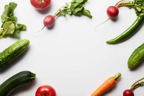 Вид зверху сирих смачних овочів з зеленим листям на білому тлі з місцем для тексту — стокове фото