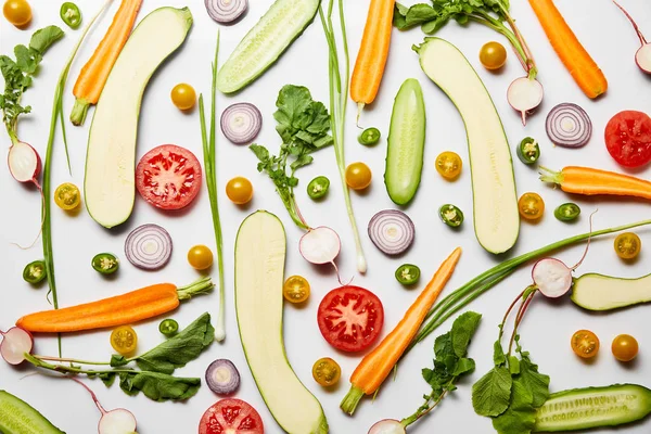 Vista superior de verduras nutritivas frescas en rodajas sobre fondo blanco - foto de stock