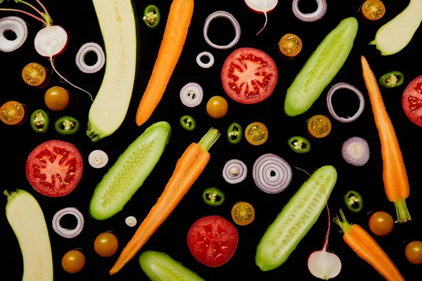 Вид сверху на свежие нарезанные овощи, изолированные на черном — стоковое фото