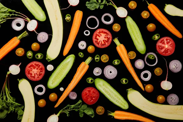 Top view of fresh organic sliced vegetables isolated on black — Stock Photo