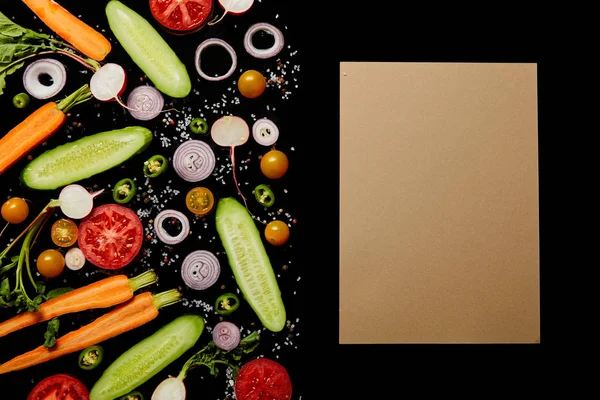 Vista dall'alto di fette di verdure fresche con sale vicino a carta bianca isolata su nero con spazio copia — Foto stock