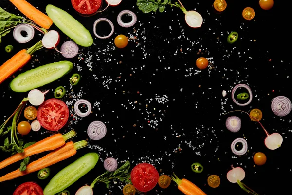 Draufsicht auf frisch geschnittenes Gemüse mit Salz isoliert auf schwarz mit Kopierraum — Stockfoto