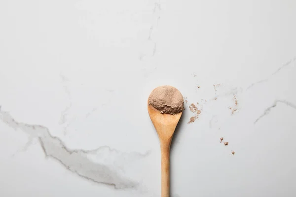 Top view of clay powder in wooden spoon on marble table — Stock Photo