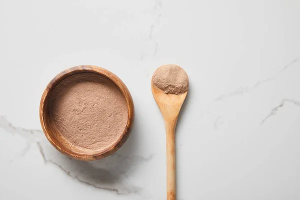 Ansicht von Tonpuder in Schüssel und Löffel auf Marmortisch — Stockfoto