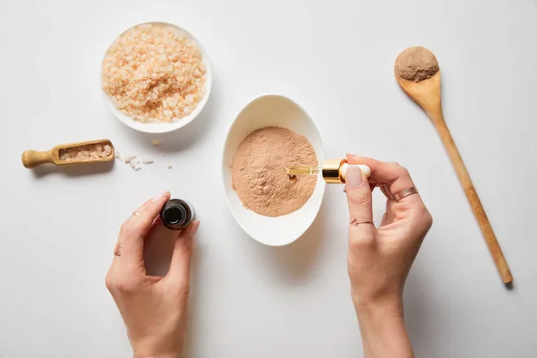 Vista recortada de la mujer que prepara cosméticos orgánicos a partir de ingredientes sobre fondo blanco — Stock Photo