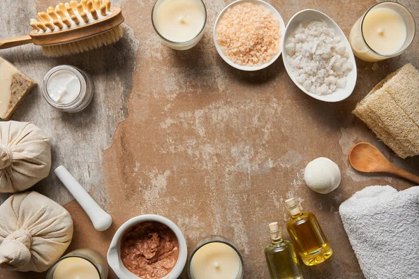 Vista dall'alto di ingredienti cosmetici naturali e forniture di bellezza vicino a candele decorative su superficie beige testurizzata — Foto stock