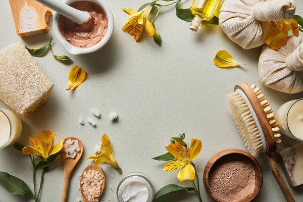 Vista superior de cosméticos orgânicos e suprimentos de beleza no fundo branco com flores amarelas — Fotografia de Stock