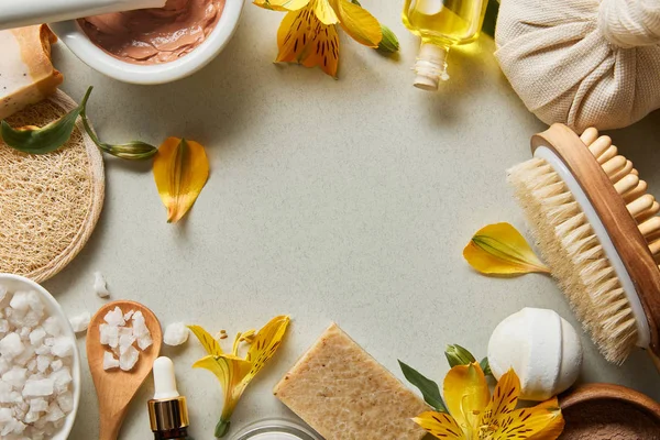 Vue de dessus des cosmétiques biologiques et des fournitures de beauté sur fond blanc avec des fleurs jaunes et de l'espace de copie — Photo de stock