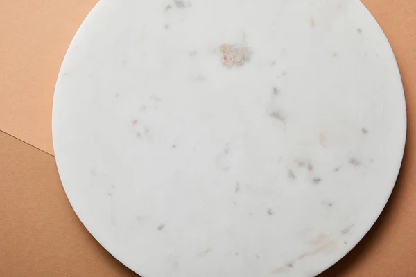 Close up view of grey marble circle on beige and brown paper background — Stock Photo