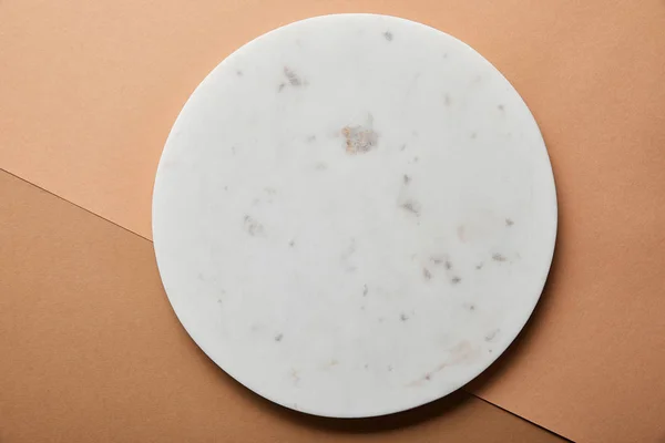 Vue de dessus du cercle de marbre gris sur fond de papier beige et brun — Photo de stock