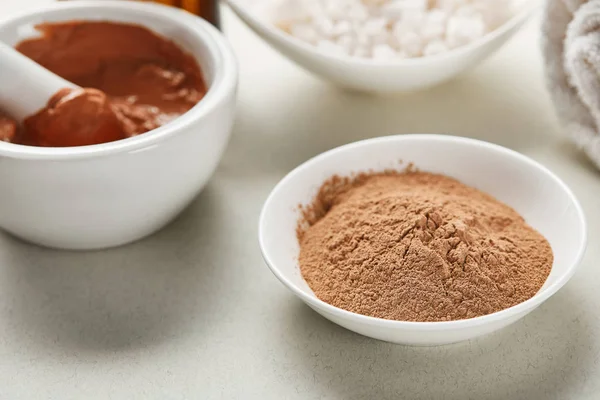 Close up view of brown clay and clay powder in white bowls — Stock Photo