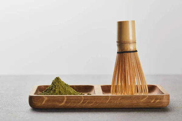 Poudre de matcha vert et fouet de bambou sur planche en bois — Photo de stock