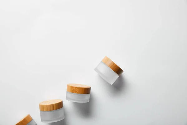 Vue de dessus des bocaux avec bouchons en bois sur blanc — Photo de stock