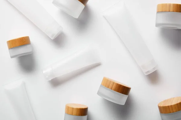 Scattered jars and cream tubes for cosmetic products on white — Stock Photo