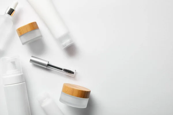 Draufsicht auf verschiedene Kosmetikbehälter auf weiß — Stockfoto