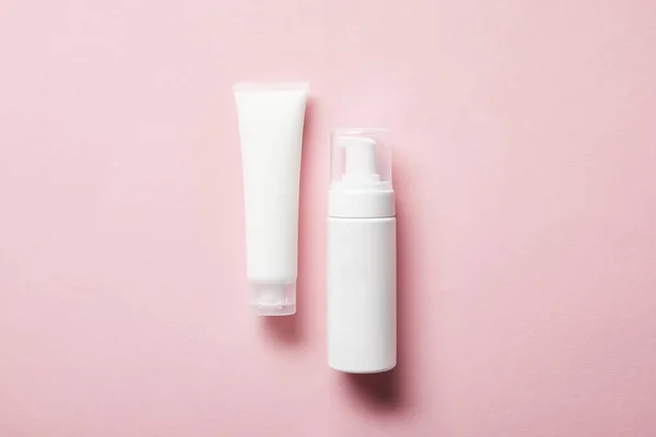 Top view of cream tube with hand cream and cosmetic dispenser on pink — Stock Photo