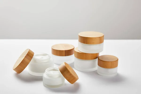 Plenty of glass jars with wooden caps on white — Stock Photo