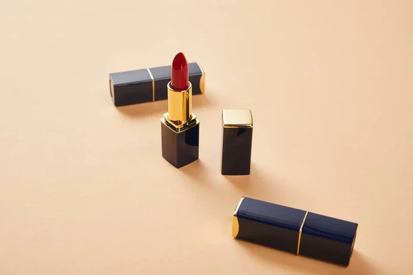 Closeup of various lipstick in tubes on beige — Stock Photo