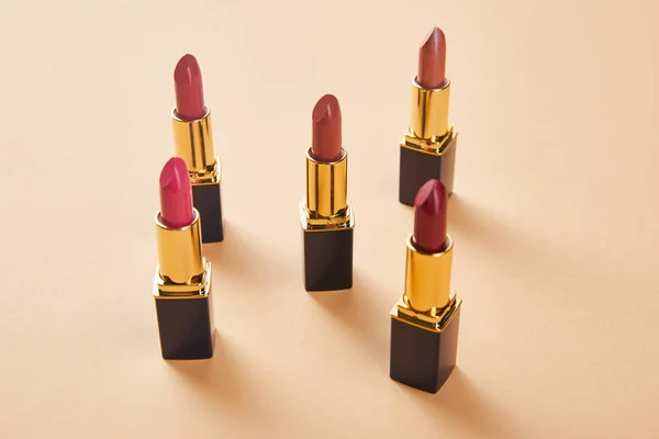 Different red shades of lipsticks on beige — Stock Photo