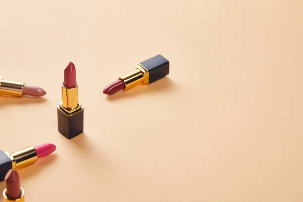Varios tonos rojos de lápices labiales en beige con espacio para copias — Stock Photo