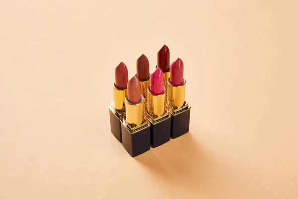 Various red shades of lipsticks on beige — Stock Photo